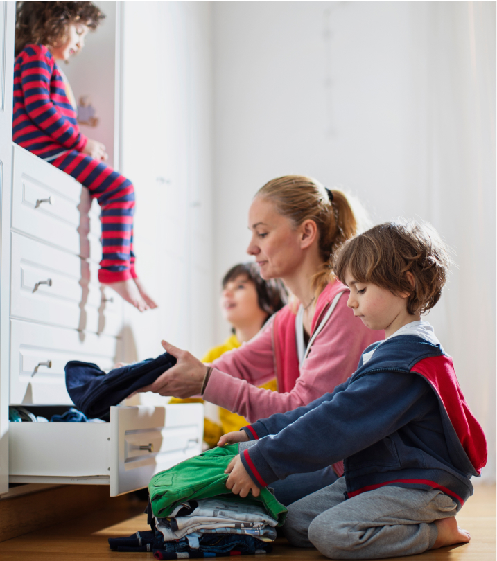 Mom with young kids putting away clean laundry