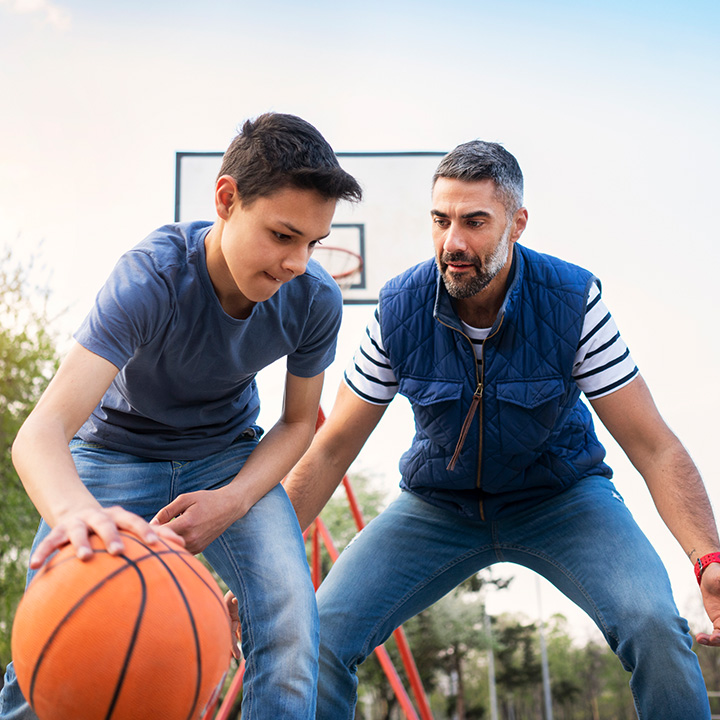 father and son playing 1-on-1 basketball