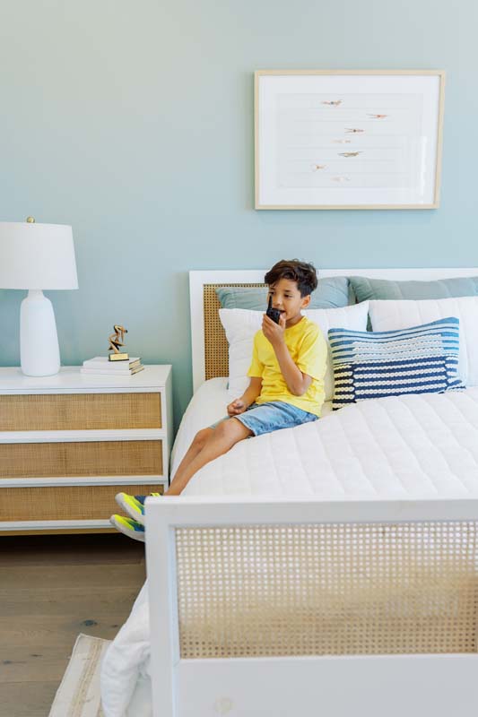 Boy on walkie-talkie sitting on a bed